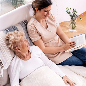 volunteer reading to a hospice patient at home